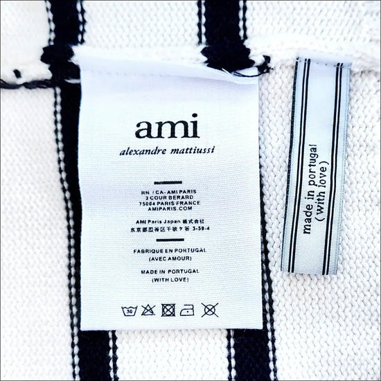 AMI Logo Cardigan label showing care instructions and origin, featuring Ami Logo in elegant design.