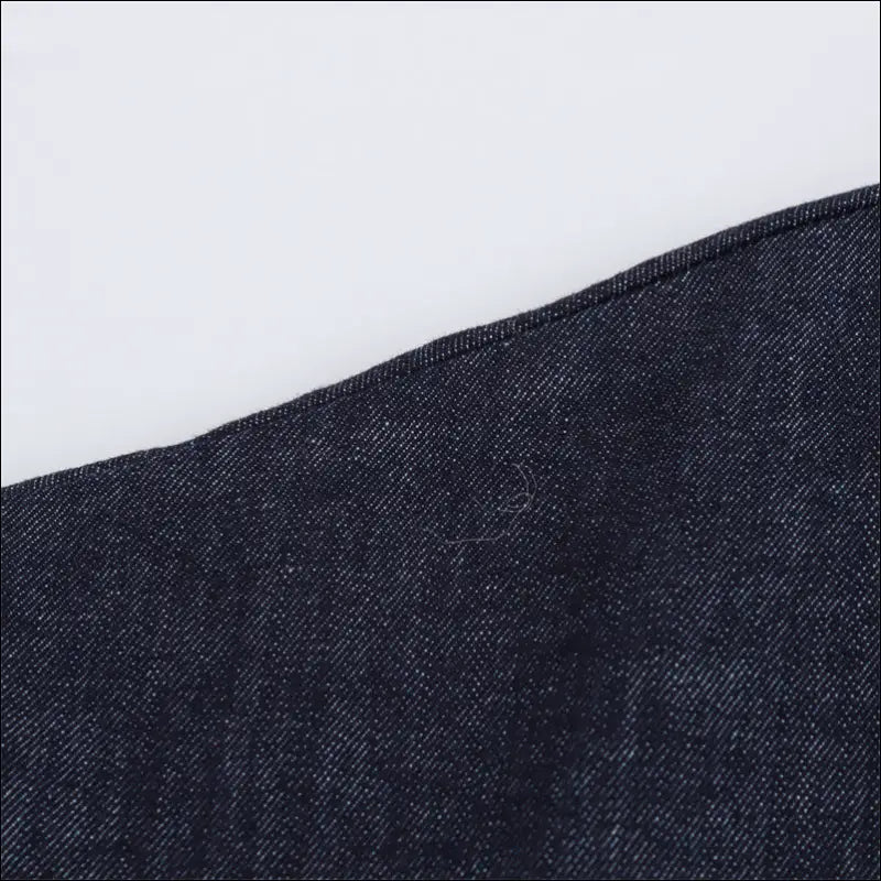 Close-up of elegant denim fabric texture showcasing stitching detail for Skjortklänning.