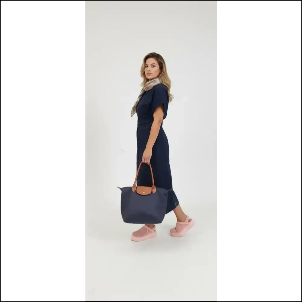 Model showcasing Large Longchamp Tote in navy blue, paired with a stylish outfit and pink shoes.